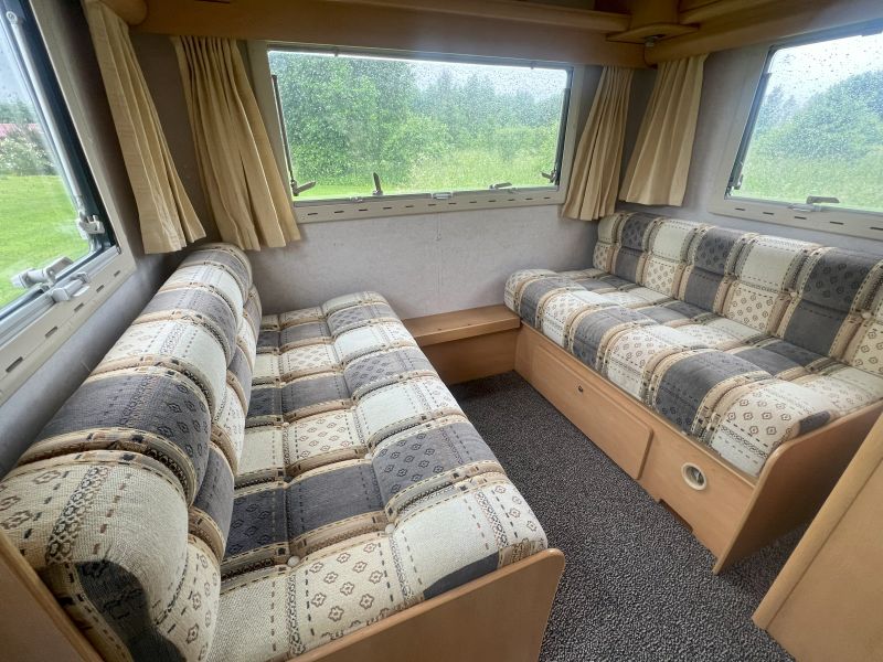 Elddis Corona haagissuvila sisevaade istumisalaga, mis muutub magamisruumiks