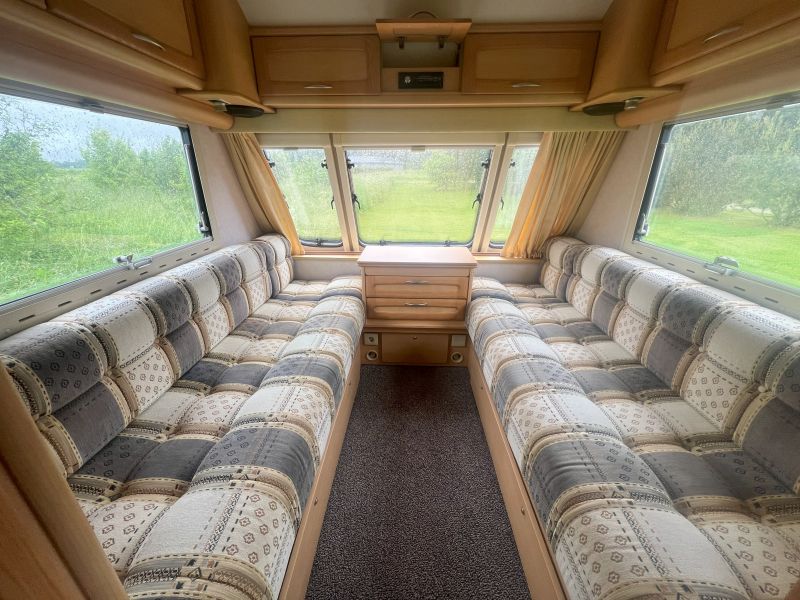 Elddis Corona haagissuvila sisevaade mugava suletud voodiga istumisalaga