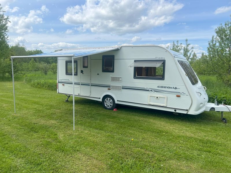 Elddis Corona haagissuvila väljatõmmatud varikatusega väljas puhkamiseks Tartus